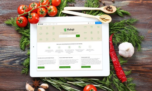 En iPad med Matinfo-siden på skjermen ligger på et bord med grønnsaker. Foto